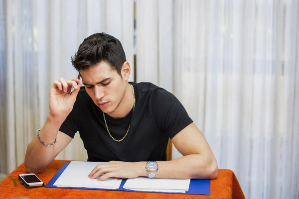 Pohledný mladý muž, studium, nebo dělat domácí úkoly — Stock fotografie
