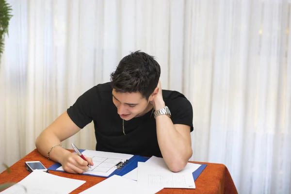 Handsome young man studying or doing homework — Stock Photo, Image