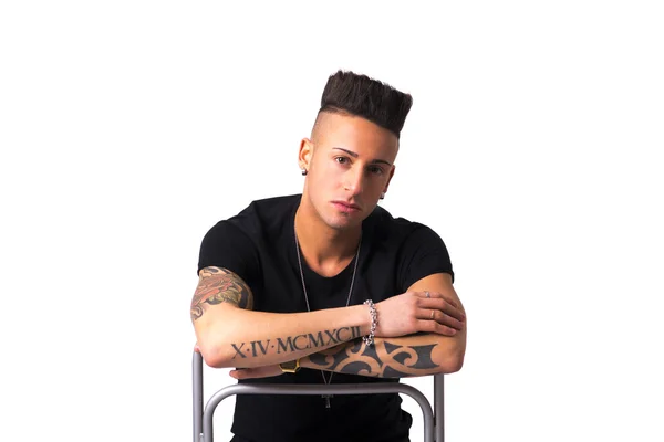 Tattooed young man sitting on chair backwards — Stock Photo, Image