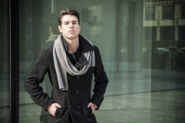 Modayı takip eden genç adam ofis penceresinin önünde duruyor.