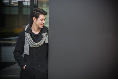 Trendy genç adam duvara karşı ayakta