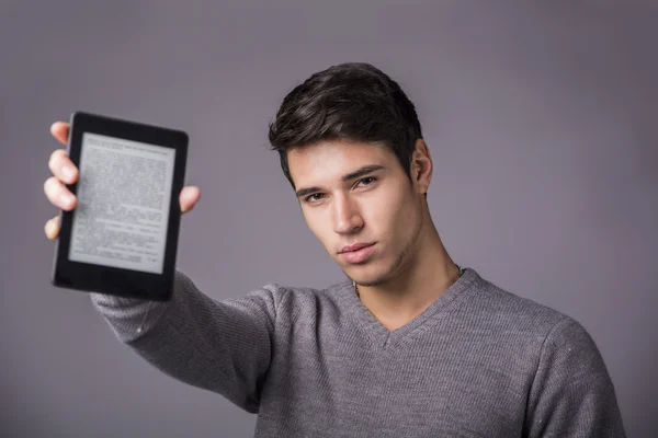 Jovem, segurando e mostrando o leitor de ebook — Fotografia de Stock