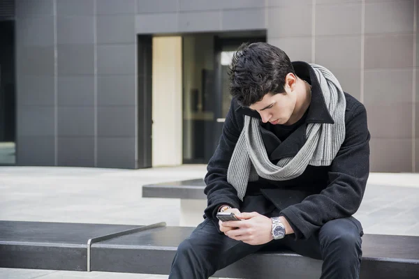 Moda hombre guapo en la moda de invierno utilizando teléfono celular —  Fotos de Stock