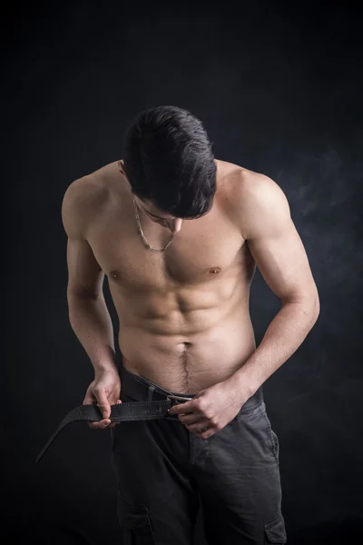 Fit shirtless young man undoing pants' belt — Stock Photo, Image