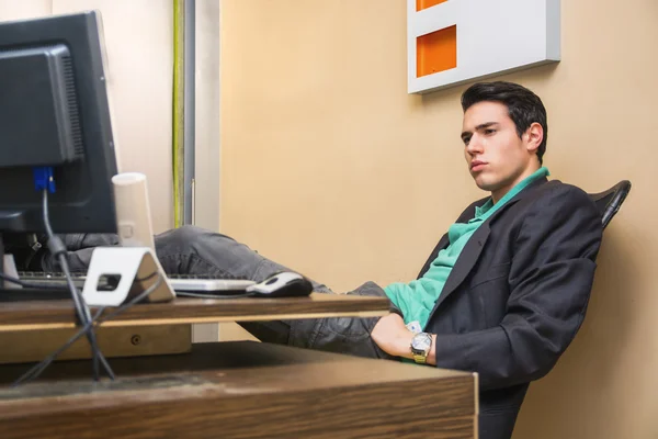Uomo d'affari giovani bello serio che si siede alla sua scrivania — Foto Stock