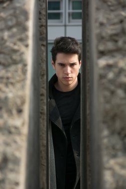 Genç adam açık iki duvar veya taşlar arasında görülen