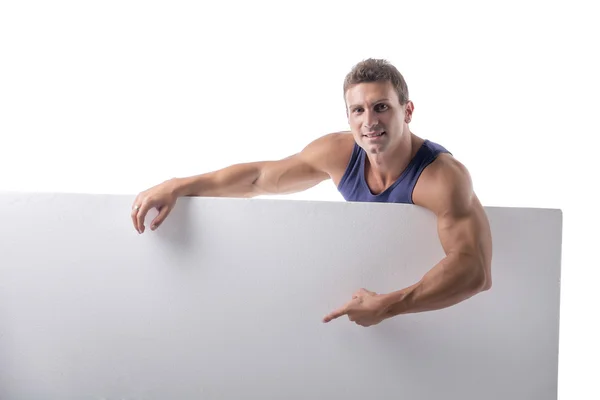 Muscular jovem atrás de uma bandeira branca horizontal em branco — Fotografia de Stock