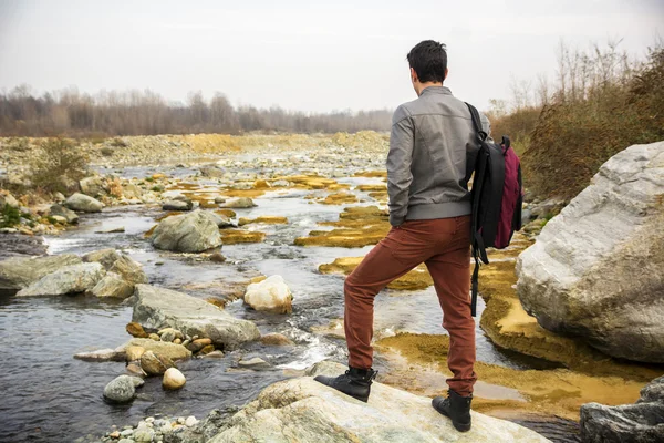 Jonge man buiten op rivier of water stroom — Stockfoto