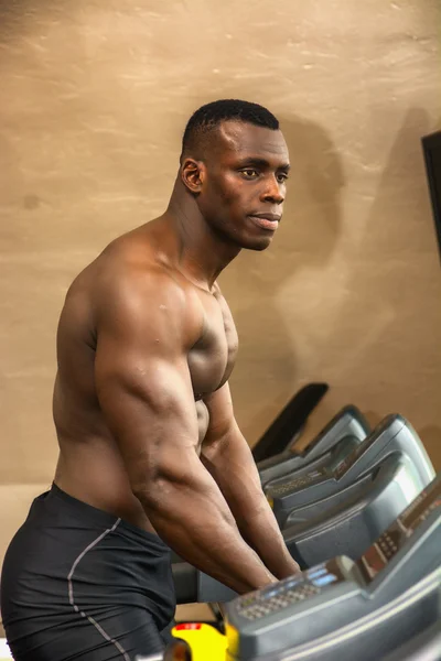 Black male bodybuilder exercising on treadmill — Stock Photo, Image