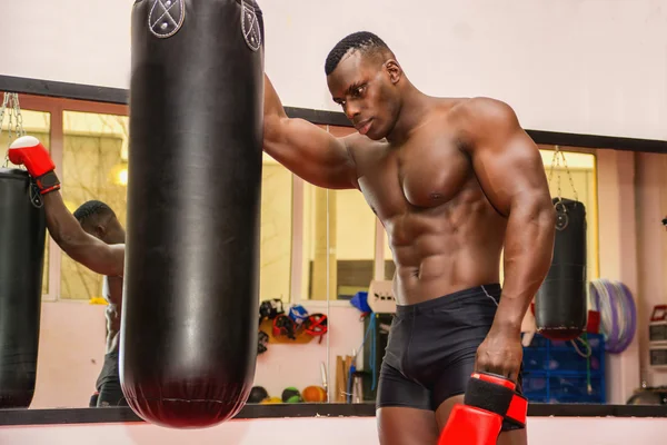 Мускулистые мужчины боксер рядом с боксерской грушей — стоковое фото