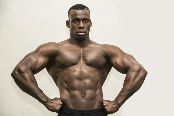 Knappe zwarte mannelijke bodybuilder poseren in studio — Stockfoto