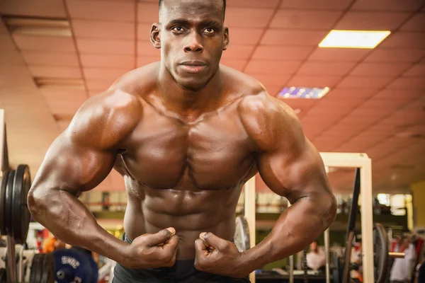 Knappe zwarte mannelijke bodybuilder poseren in de sportschool — Stockfoto