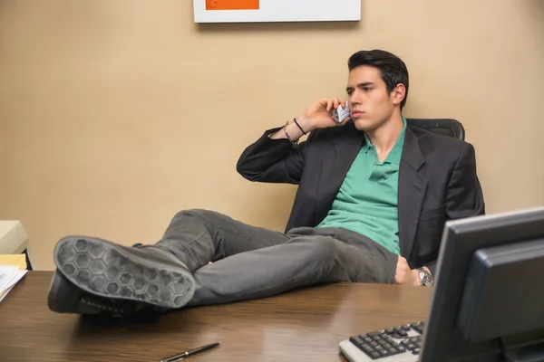 Ung affärsman vid skrivbord prata telefon — Stockfoto