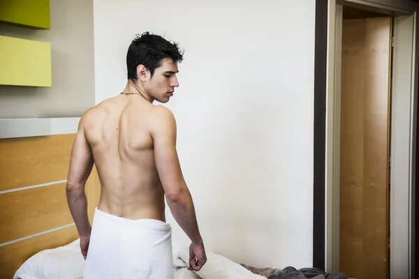 Молодой мужчина без рубашки, покрытый полотенцем — стоковое фото