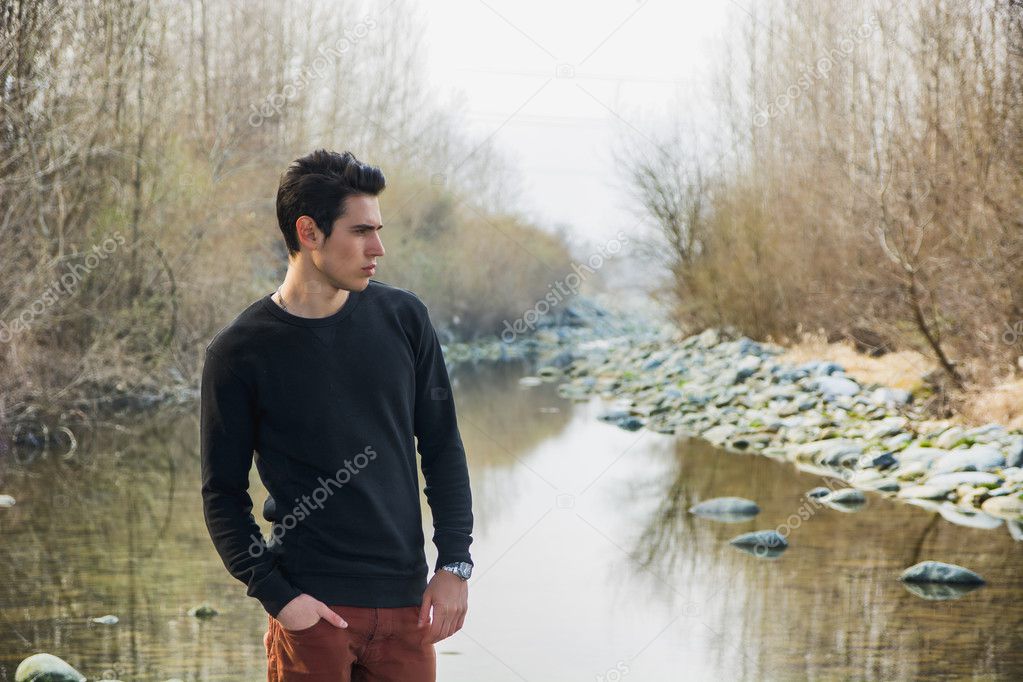 Young man outdoor in nature, at river
