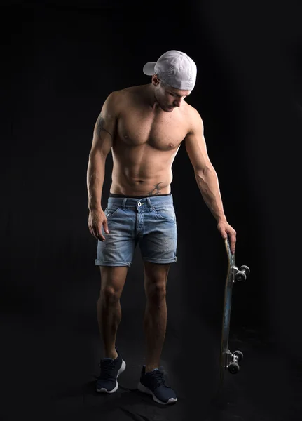 Homem sem camisa muscular com skate — Fotografia de Stock