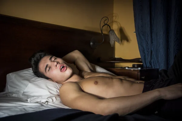 Genç adam yatakta uyuyor. — Stok fotoğraf