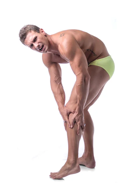 Hombre musculoso guapo sosteniendo su pierna y la rodilla en dolor —  Fotos de Stock