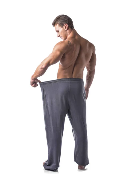 Male bodybuilder has lost weight, wearing large pants — Stock Photo, Image