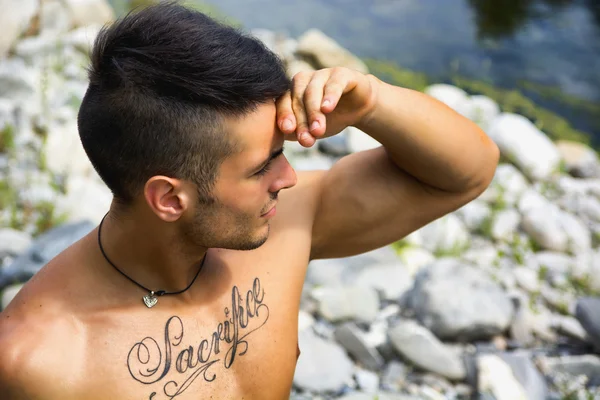 Giovane senza camicia muscolare in natura con le piante — Foto Stock