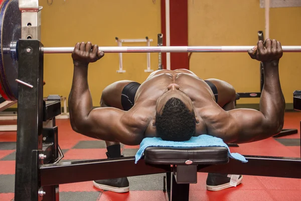 Hunky muscular black bodybuilder working out in gym — Stock Photo, Image