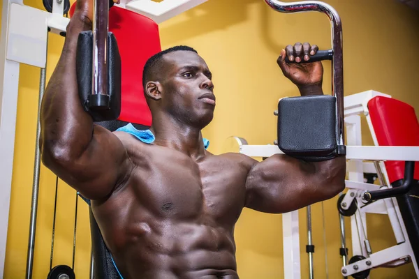 Hunky muscular black bodybuilder working out in gym — Stock Photo, Image