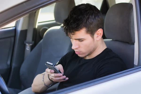 Отвлекаться молодой человек с помощью сотового телефона вождения — стоковое фото
