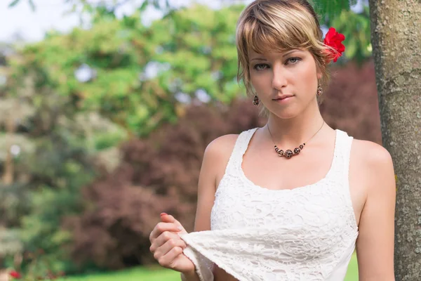 Bahçe veya park kırmızı gül ile çekici genç kadın — Stok fotoğraf