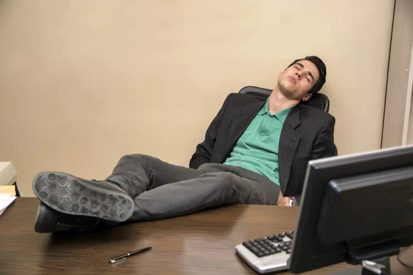Zmęczony młody biznesmen śpiący przy biurku — Zdjęcie stockowe