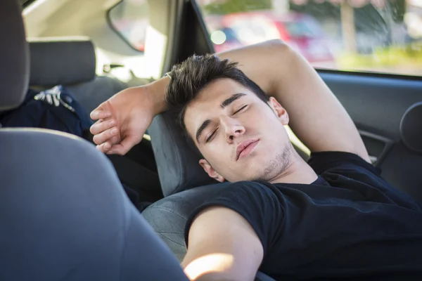 Joven durmiendo dentro de su coche, agotado — Foto de Stock