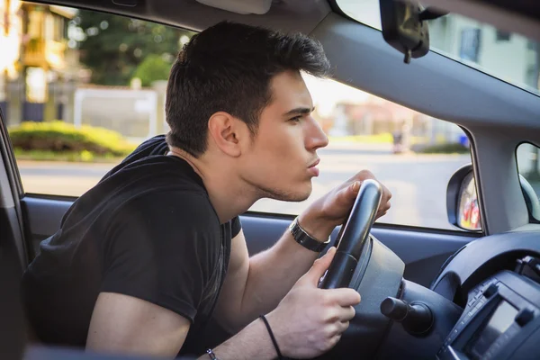 若い男の車のステアリング ホイール前方に傾い — ストック写真