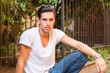 Yol kenarında oturan çekici genç adam