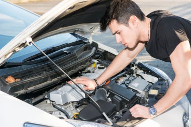 Bir araba motoru tamir etmeye çalıştığını yakışıklı genç