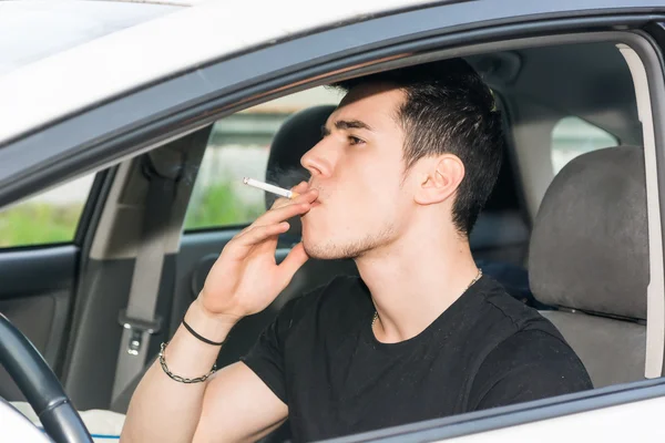 Young Man smoking cigarette while Driving — Stock Photo, Image