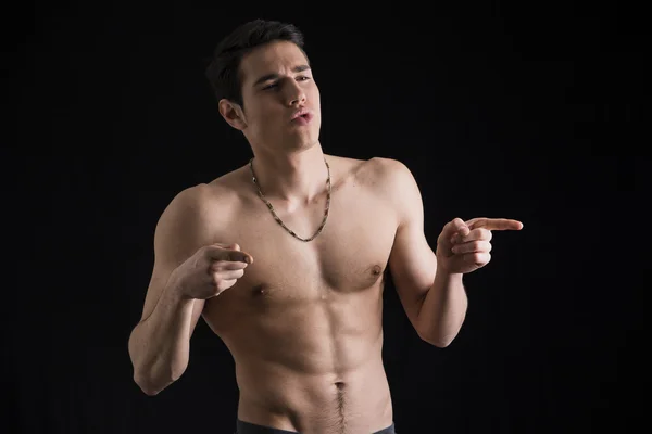 Handsome shirtless young man pointing fingers to a side — Stock Photo, Image