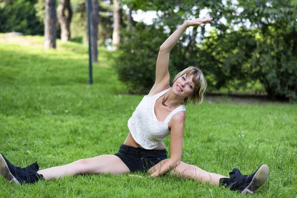 Jovem mulher a fazer um exercício de alongamento ao ar livre — Fotografia de Stock