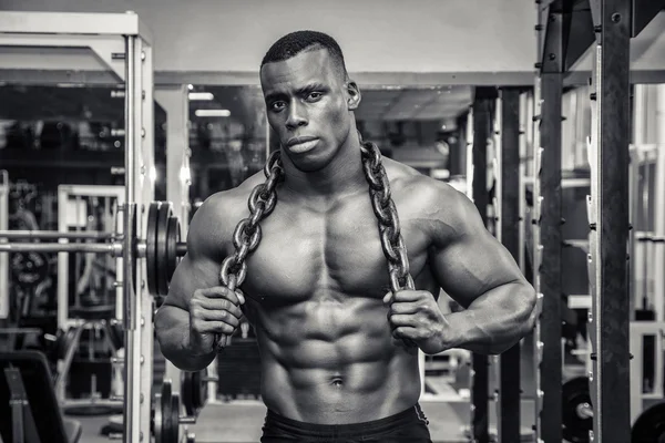 Attractive hunky black male bodybuilder posing with iron chains — Stock Photo, Image