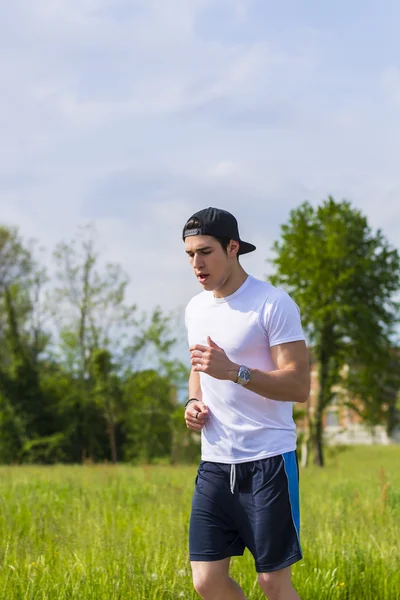 Corsa e jogging sulla strada nel paese del giovane — Foto Stock