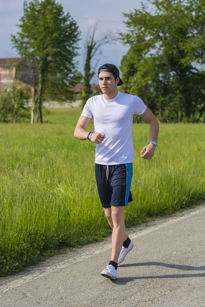 Young man running and jogging on road in country — Stock Photo, Image