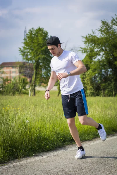 Young man getting injured while running spraining an ankle — Stock Photo, Image