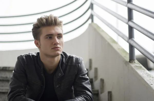 Blond ung man sitter på trappan utanför — Stockfoto