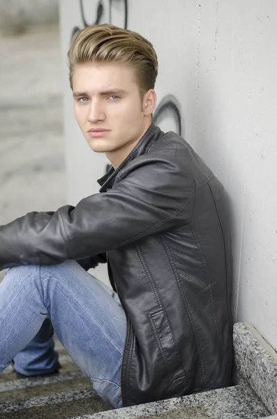 Blonder Junge Mann sitzt auf der Treppe außerhalb — Stockfoto