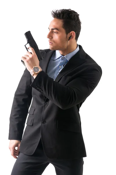 Элегантный человек с пистолетом, одетый как шпион или секретный агент — стоковое фото