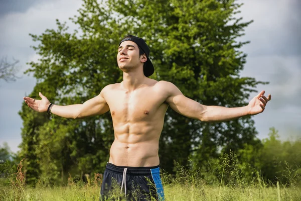 Giovane senza camicia che celebra la natura in campagna — Foto Stock