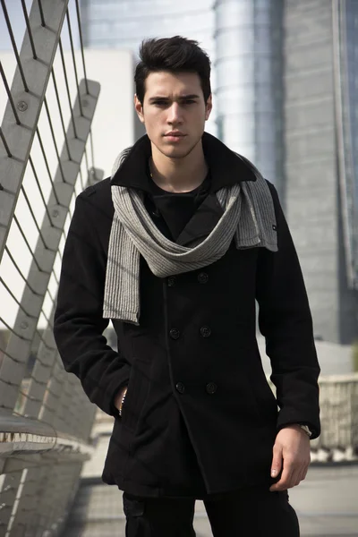 Mężczyzna w czarnym płaszczu, stojący tuż przy centrum miasta — Zdjęcie stockowe