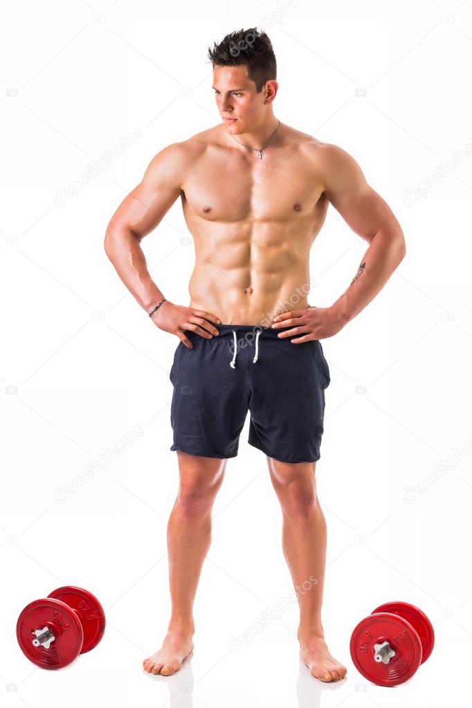 Shirtless young man holding dumbbells