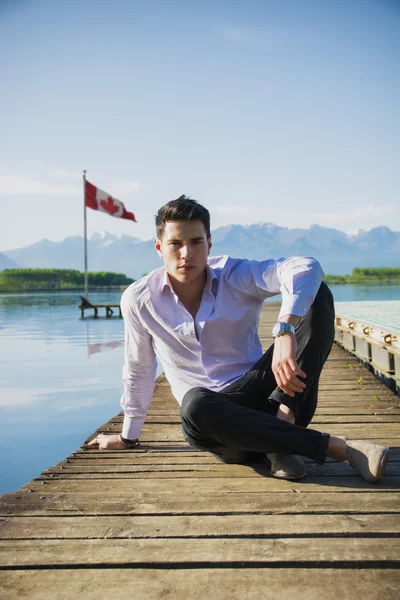 Hombre joven en un lago en un día soleado y tranquilo — Foto de Stock