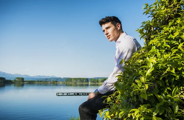年轻男子在一个湖在阳光明媚、 和平的一天 — 图库照片