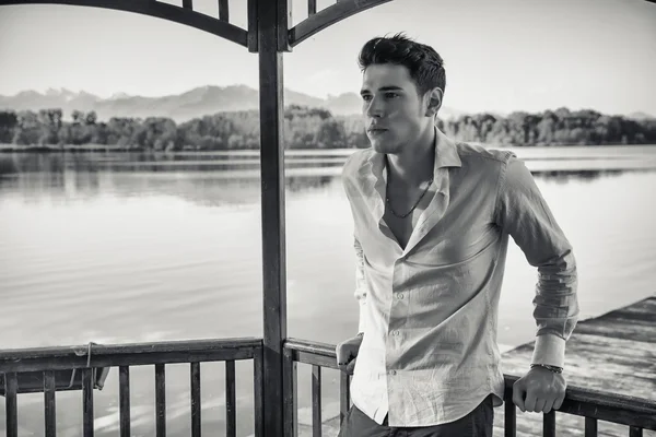 Güneşli, huzurlu bir gün bir göl üzerinde genç adam — Stok fotoğraf