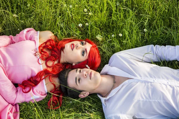 Coppie che si siedono nel giardino tra fiori — Foto Stock